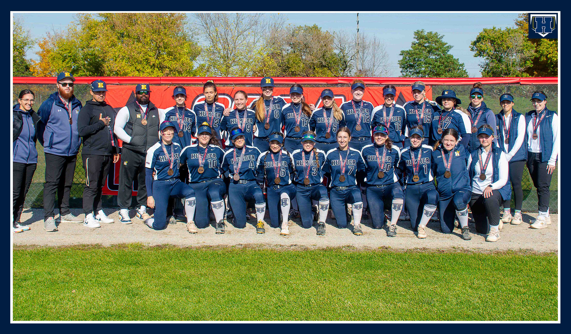 Softball team photo wearing their bronze medals