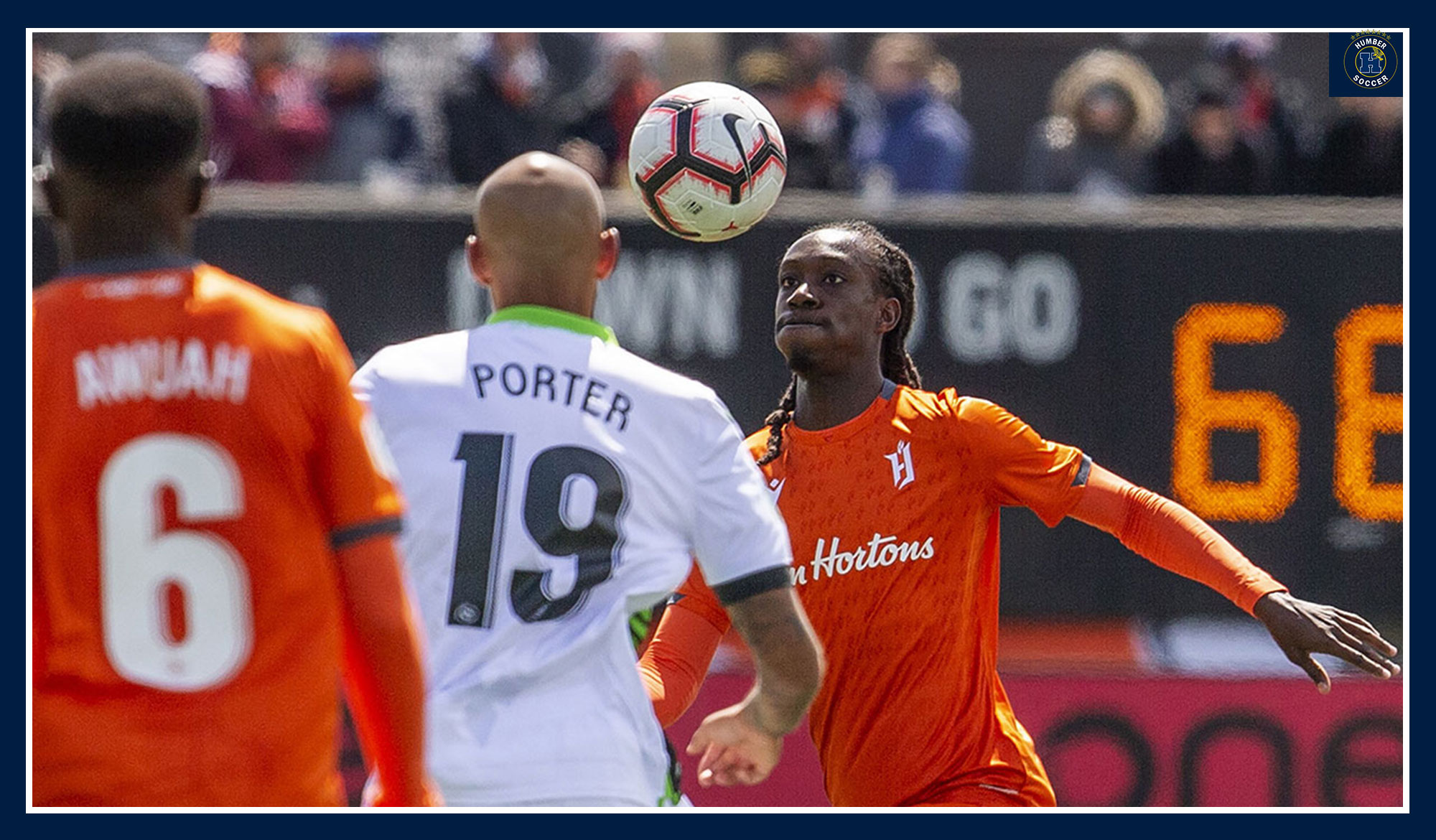 Thomas playing a ball wearing the orange kits for Forge FC.
