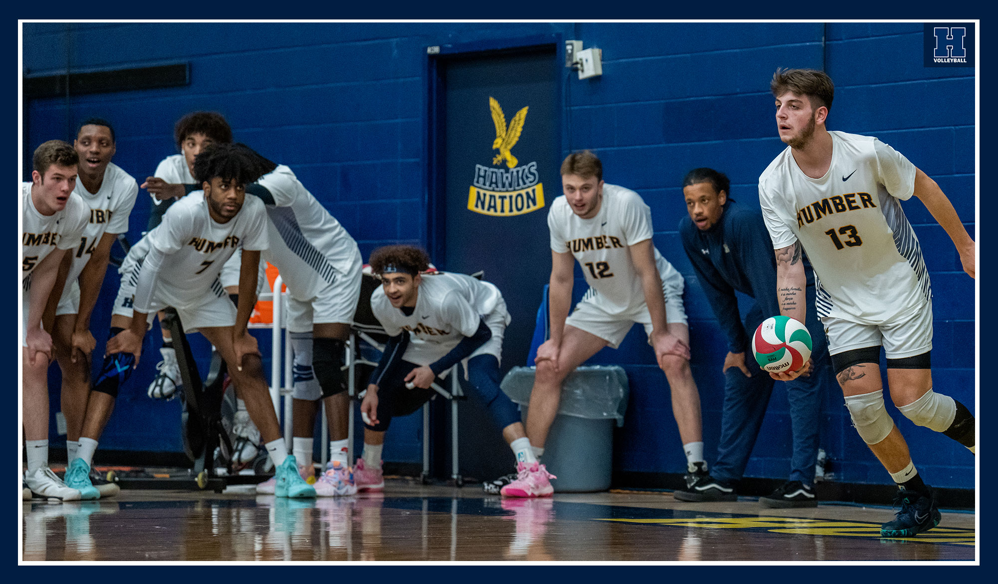 Jake Gomes serving as the team looks on