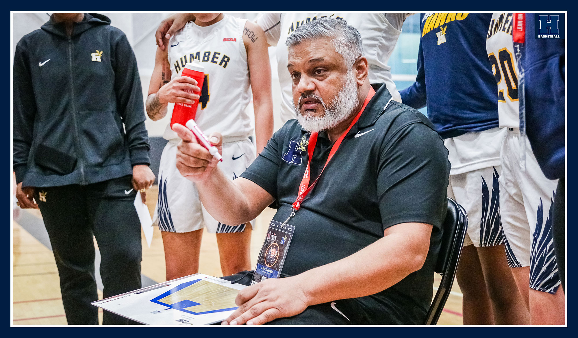 Ajay Sharma drawing up a play during a team huddle