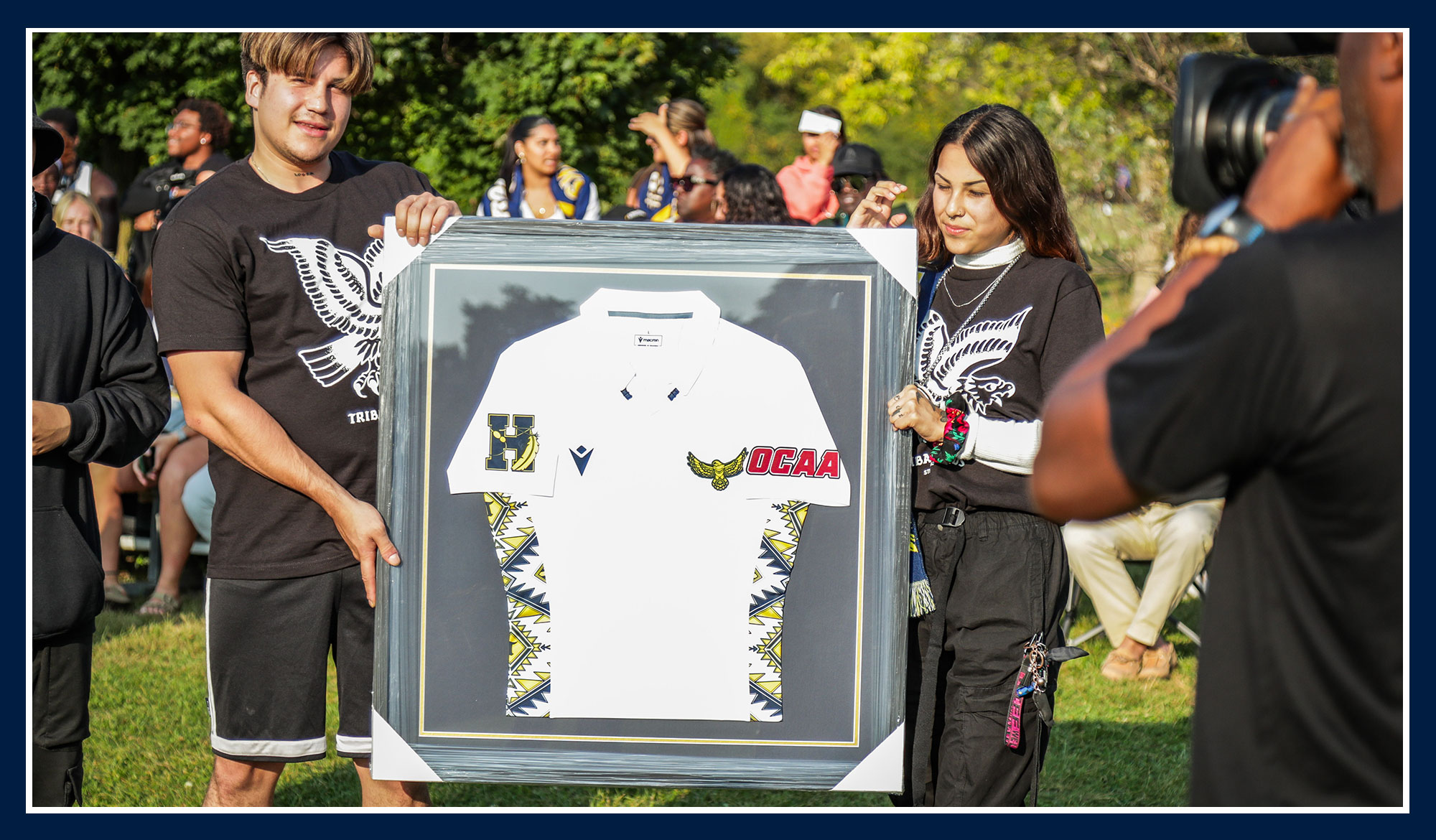Tribal Lands holding up the jersey they helped design